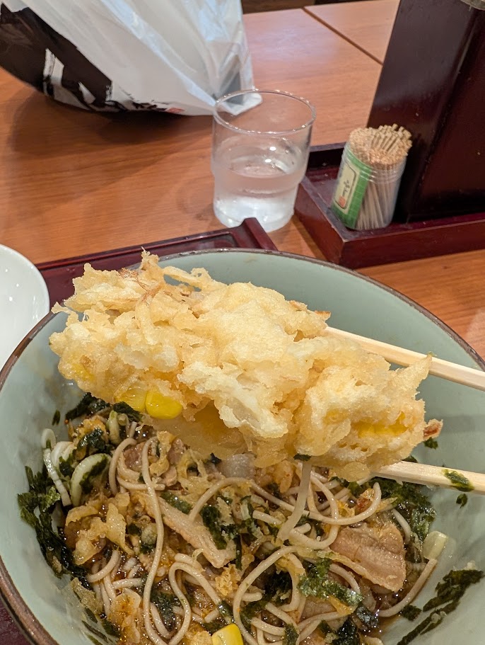 とうもろこしのかき揚げを箸で持ち上げたところ