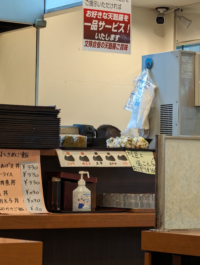 文殊 成増店のカウンターと、入場券で天ぷら一品サービスの貼り紙