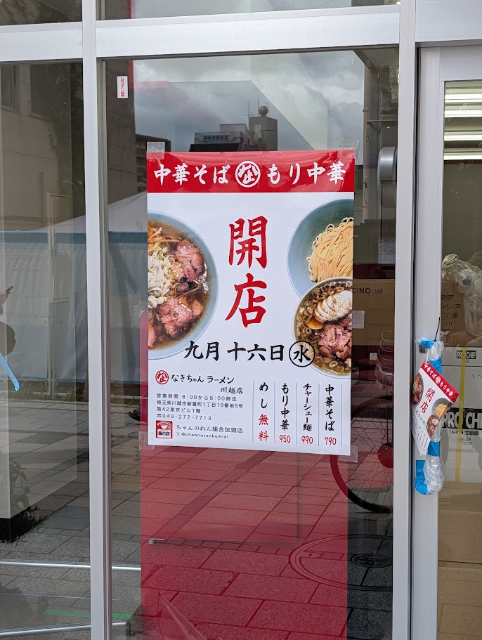 ガラス扉に貼られた開店ポスターとメニュー価格